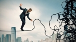 Businessman over city rope Businessman over city rope