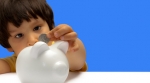 Child putting money piggy bank Child putting money piggy bank
