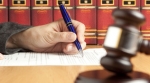 Gavel and judge's hand signing papers. Gavel and judge's hand signing papers.