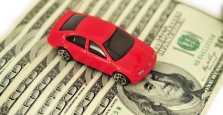Car sitting on hundred dollar bills