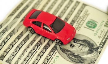 Car sitting on hundred dollar bills Car sitting on hundred dollar bills