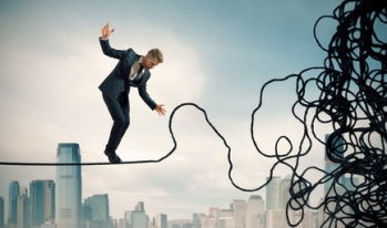 Businessman over city rope Businessman over city rope