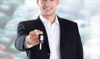 Smiling salesman with keys to new car Smiling salesman with keys to new car