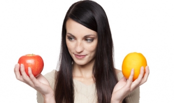 Comparing apples and oranges Girl comparing an apple and an orange