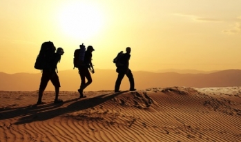 Three silhouettes of hikers in the desert Three silhouettes of hikers in the desert
