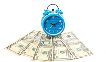 alarm clock sitting on money alarm clock sitting on money