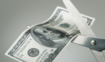 hundred dollar bill being cut by scissors hundred dollar bill being cut by scissors