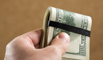 hand holdin gmoney wad in clip hand holding money wad in clip