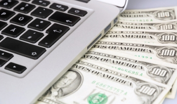 dollars under a laptop dollars under a laptop