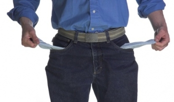 No money in pocket Man pulling his empty pockets inside out