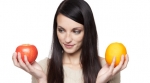 Comparing apples and oranges Girl comparing an apple and an orange