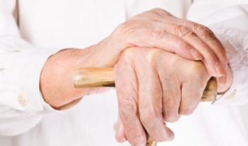 Elderly hands resting on cane Elderly hands resting on cane