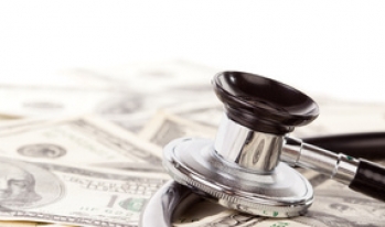 Stethoscope sitting on pile of money Stethoscope sitting on pile of money