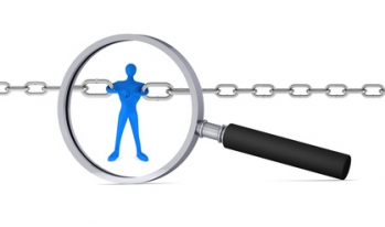 Magnifying glass on a man holding two chains together Magnifying glass on a man holding two chains together
