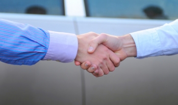 handshake in front of a car handshake in front of a car