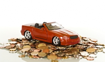 Car on Coins Toy car sitting on a pile of coins