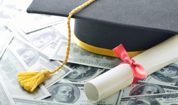 A graduation cap and diploma on hundred dollar bills A graduation cap and diploma on hundred dollar bills