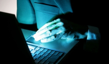 Suspicious man working on a laptop computer Suspicious man working on a laptop computer