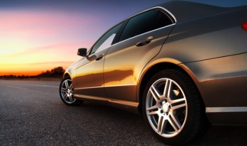 Luxury car driving into sunset Luxury car driving into sunset