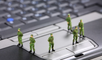 Military figurines standing on computer keyboard Military figurines standing on computer keyboard