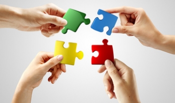 Multiple hands putting puzzle pieces together Multiple hands putting puzzle pieces together